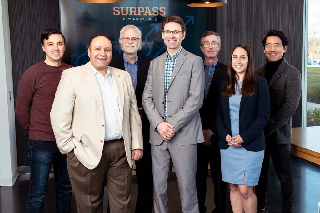 The team working on the Photoacoustic Retinal Prosthesis project stands together in a conference room. Team member names are listed in the text below the image.